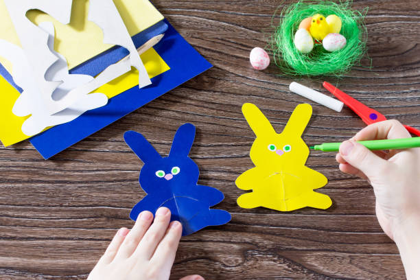 istock Child draws items crafts. Create Easter baby gift napkin holder paper easter bunny. Made by hand. Children's Art Project, needlework, crafts for children. 646179190