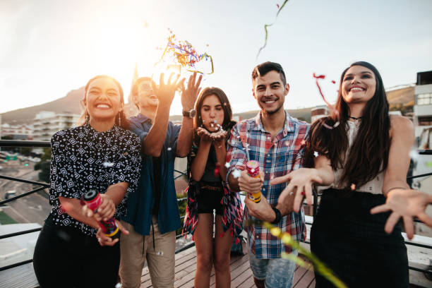 istock Young people enjoying rooftop party with confetti 646183520