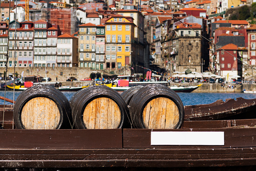 Port Wine barrels in a boat in the Douro River with the city of Porto in the background