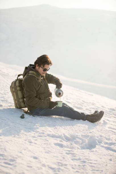 istock Man holding a cup of hot tea in mountain 646189710