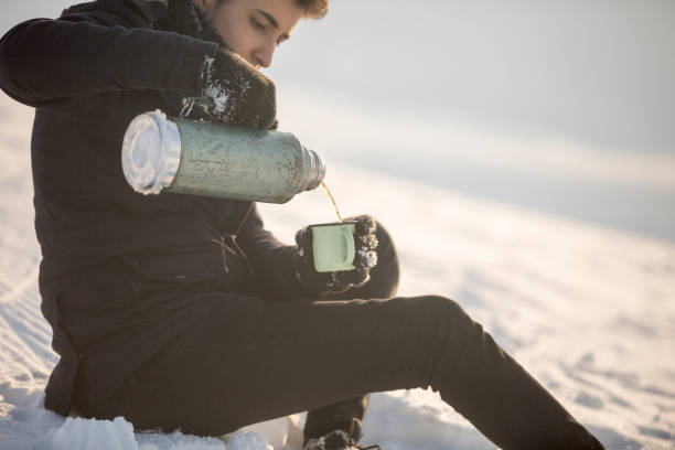 istock Man holding a cup of hot tea in mountain 646193080
