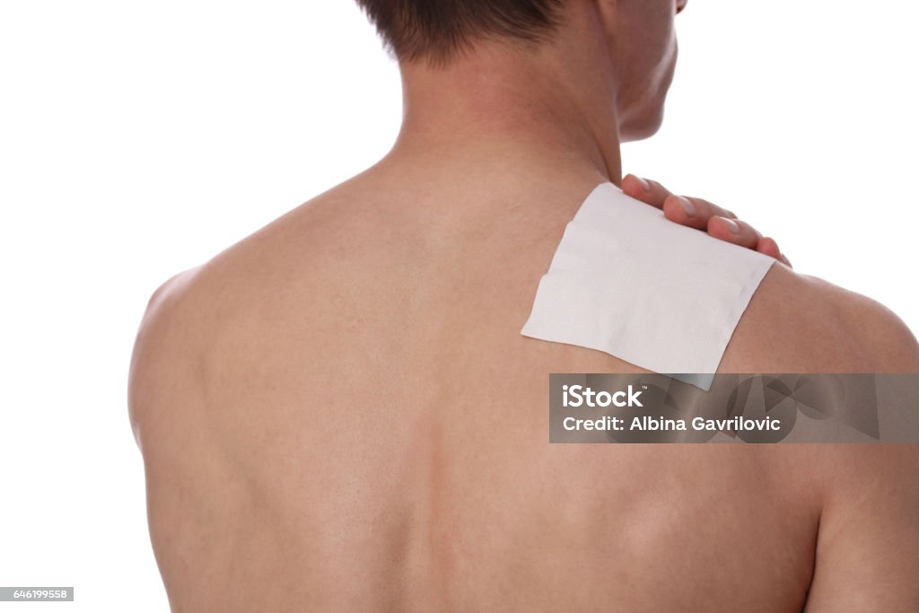 Medicated pain relief patch, plaster. man with back, neck pain. Pain relief and health care concept isolated on white. Adhesive Bandage Stock Photo