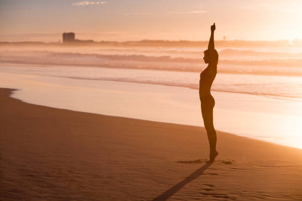 istock Woman practicing yoga on the beach 646200880