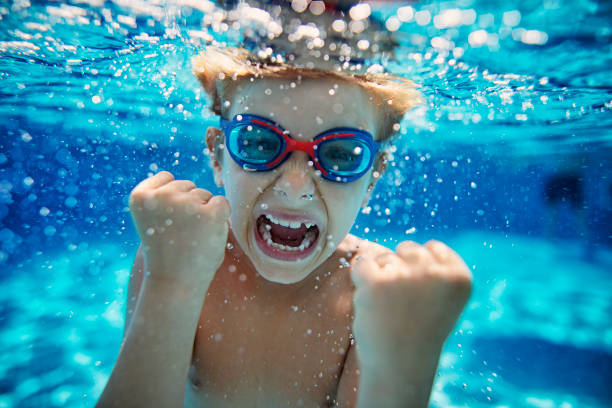 маленький мальчик в бассейне кричит под водой - child swimming pool swimming little boys стоковые фото и изображения