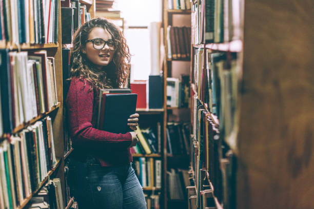 istock Pretty high school or college student in library 646213900