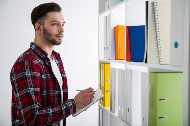 istock Side view of a man in checkered shirt in library 646218780