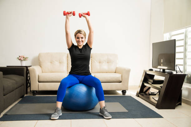 istock Pretty girl lifting weights at home 646222036