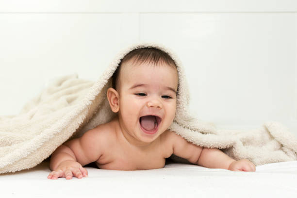 istock Cute baby boy in bed under a fluffy blanket 646231728