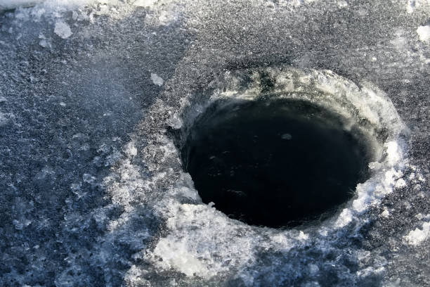 istock Ice Fishing Hole with Black Water 646235012