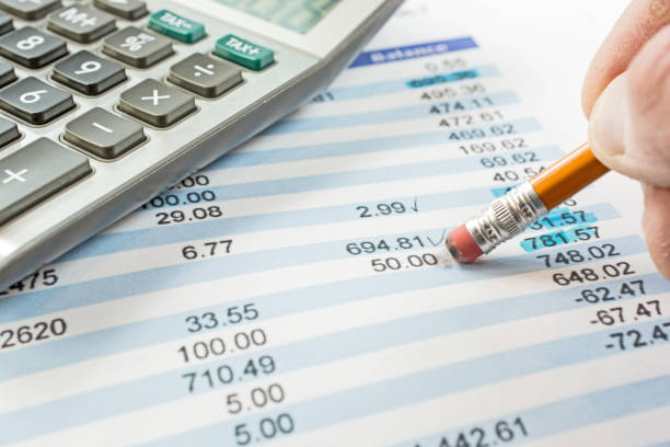 Balancing a bank statement close-up with pencil and calculator stock photo