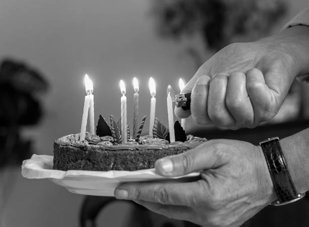 istock Light candles on birthday cake black and white 646240078