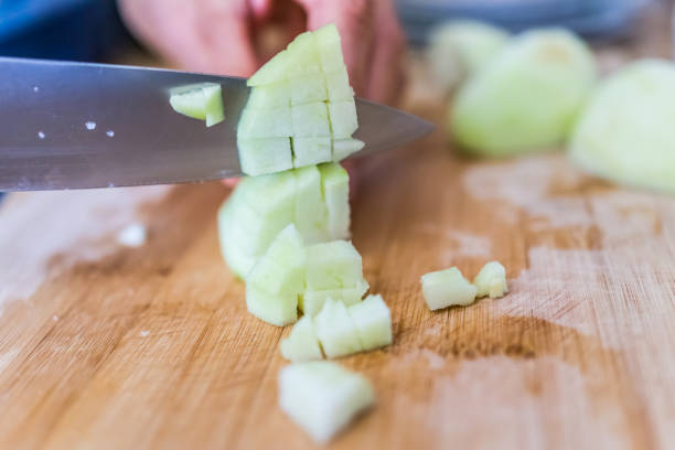 Cook chopping green peeled granny smith apples on board