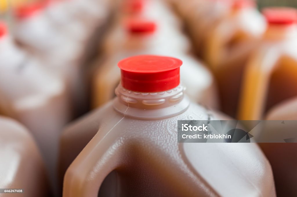 Rows of plastic gallon jars on display filled with cider Rows of plastic gallon jars on display filled with apple cider Autumn Stock Photo