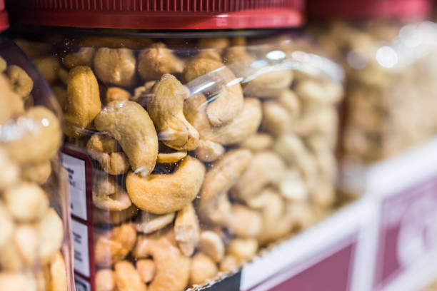 Macro closeup of roasted cashews in plastic jars