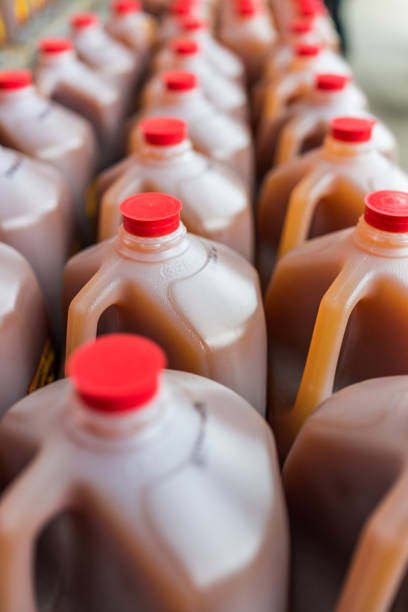 istock Rows of plastic gallon jars filled with apple cider 646259790