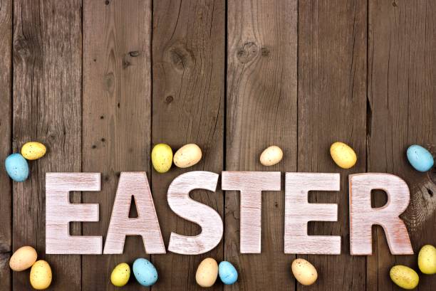 letras de pascua de madera blanca con huevos de pascua sobre madera rústica - easter text single word paint fotografías e imágenes de stock