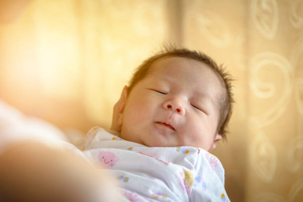 istock asian newborn sleeps on mother hand 646271838
