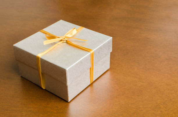 istock Silver gift box with golden ribbon 646285318