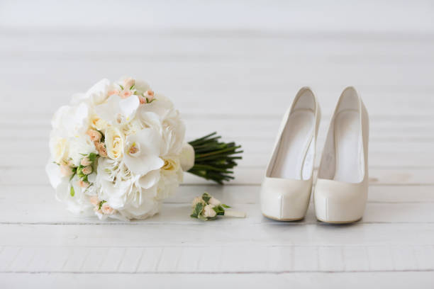 istock Wedding bouquet of white orchids and shoes 646313232