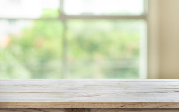 istock Wood table top on blur green garden from window view. 646328524