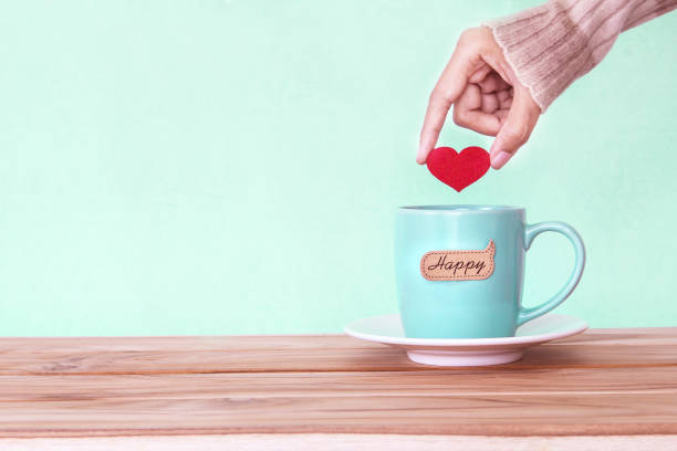 istock hand holding  red heart shape put into a Coffee cup 646340914