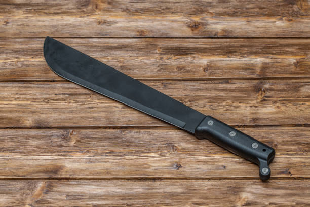 Machete for cutting grass on wooden background Machete for cutting grass on brown wooden background Machete stock pictures, royalty-free photos & images