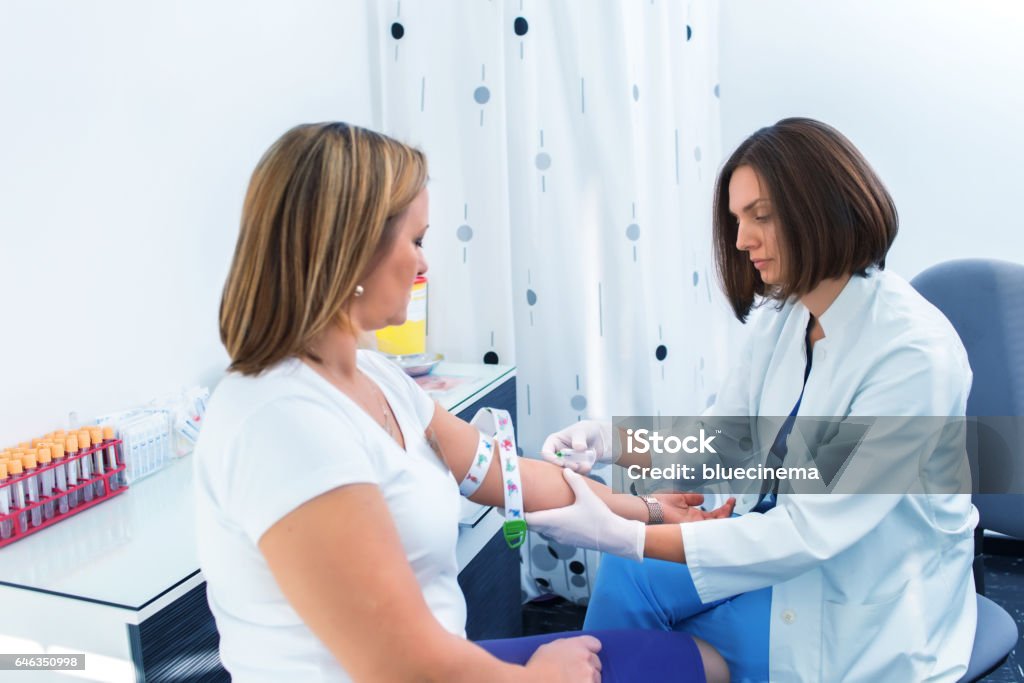 Nurse taking blood sample Nurse getting blood from on a female donor Blood Donation Stock Photo