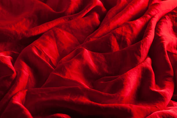 istock wrinkled scarlet red silk fabric background. 646353352