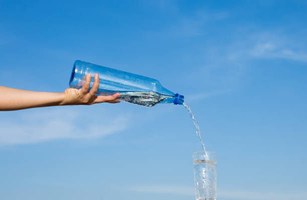 istock Pure water poured overhand from a bottle into a glass 646353454