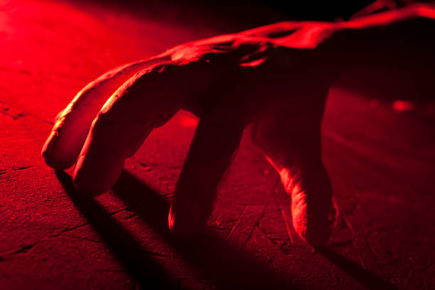 istock Creepy crawling hand in red light inside a haunted house. Halloween prop. 646357644