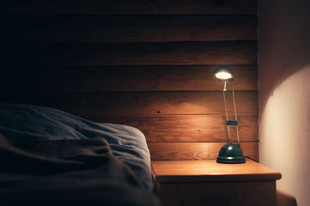 lampada da camera da letto su un tavolo da notte - comodino foto e immagini stock