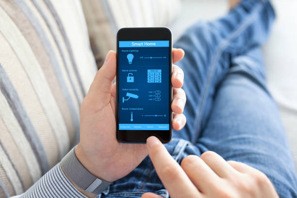 istock man holding phone with smart home on screen 646363216