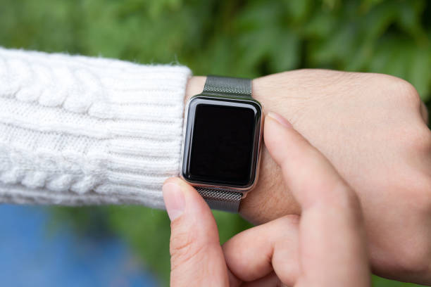 istock men hands with smart watch on the street 646363586