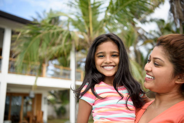 Portrait of mother with daughter smiling Young woman holding young cute girl with long dark hair sri lankan culture photos stock pictures, royalty-free photos & images