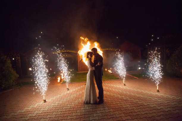 istock Young groom and bride with two burning hearts fireshow 646387922