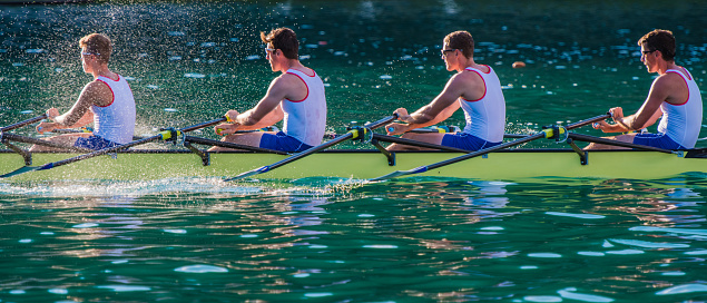 Quad scull rowing boat in water.