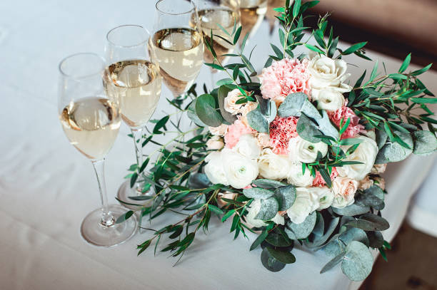 bouquet di nozze di bianco e biege con un nastro sul tavolo con sei bicchieri di champagne - flower head bouquet built structure carnation foto e immagini stock