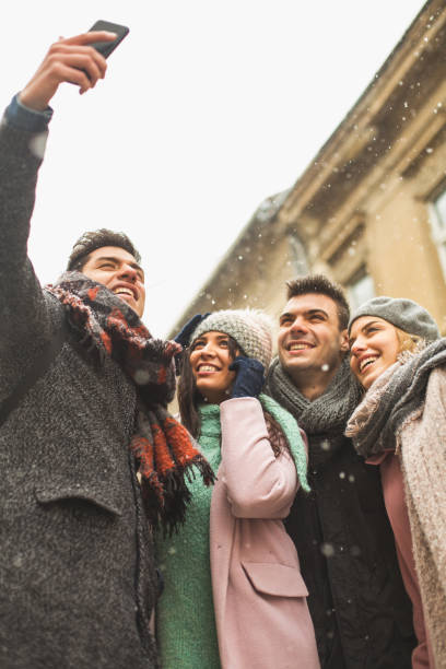 istock Friends taking self-portrait with camera phone outdoors 646410268