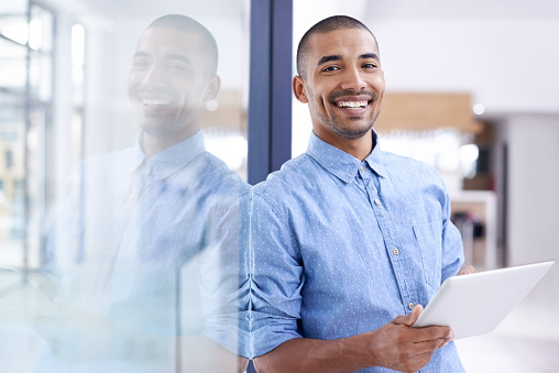 Shot of a young entrepreneur using a digital tablet in a modern office