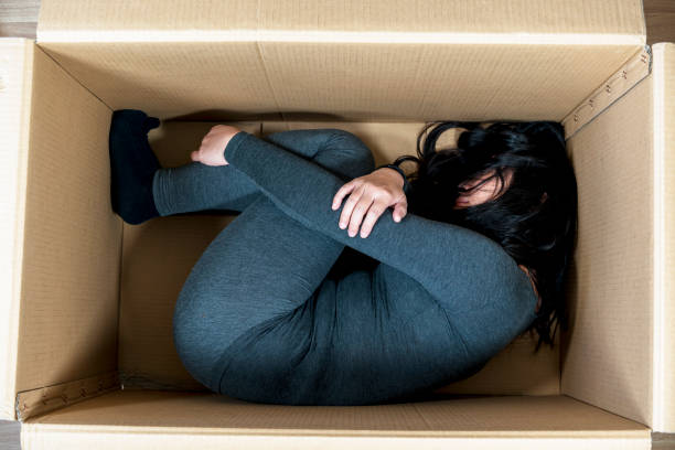 istock girl sleeping in cardboard box 646416702