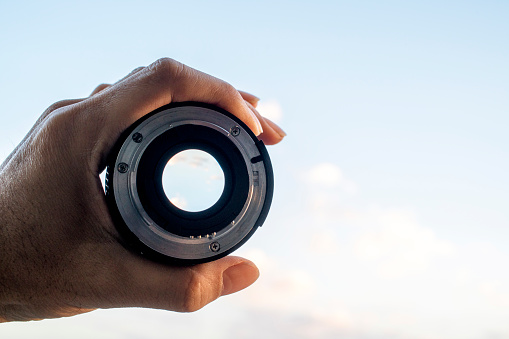 hand holding lens, looking at sky