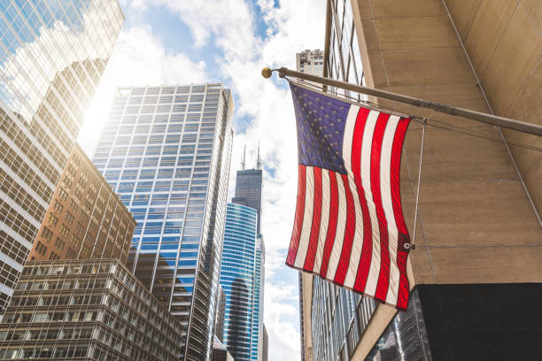 bandiera usa a chicago con grattacieli sullo sfondo - american business foto e immagini stock