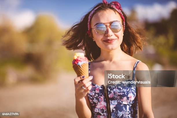 Young Woman Eating Ice Cream On The Beach Stock Photo - Download Image Now - Ice Cream, Summer, Eating