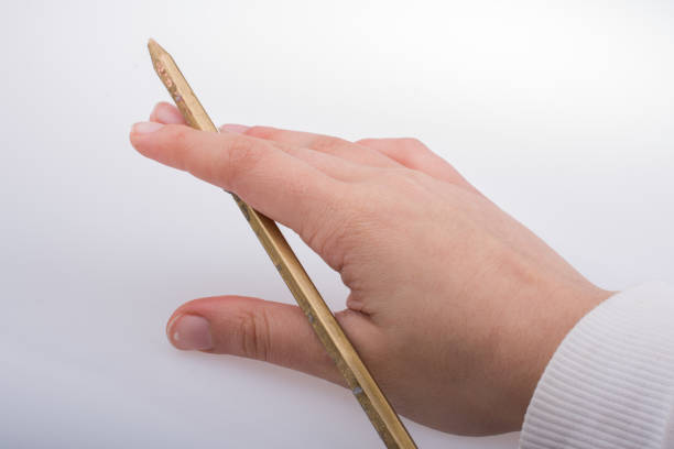 istock Hand holding a gold color pencil  in hand 646431124