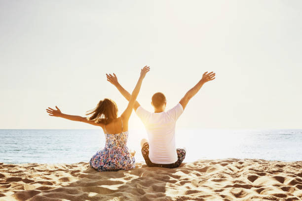 Happy couple beach holidays concept Happy couple having fun on background of sunset beach. Sea vacations concept. Space for text people jumping sea beach stock pictures, royalty-free photos & images