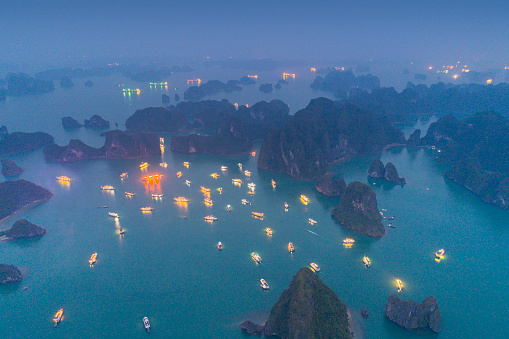 Unique Aerial shot of the Halong Bay (Vịnh Hạ Long) at Night with the illuminated cruise ships lightening up this UNESCO World Heritage Site.