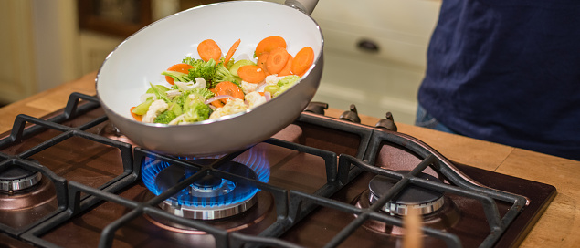 Vegetables cooking in frying pan.