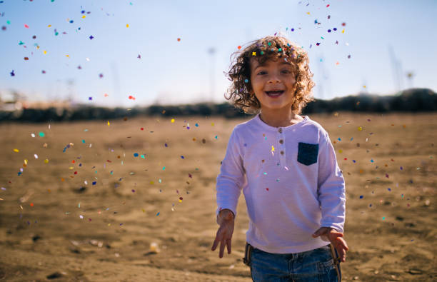 istock Young boy playing at the beach with confetti 646438484