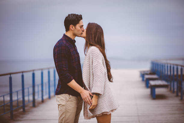Young Couple Standing On Pier And Kissing Stock Photo - Download Image Now  - Kissing, Beach, Love - Emotion - iStock