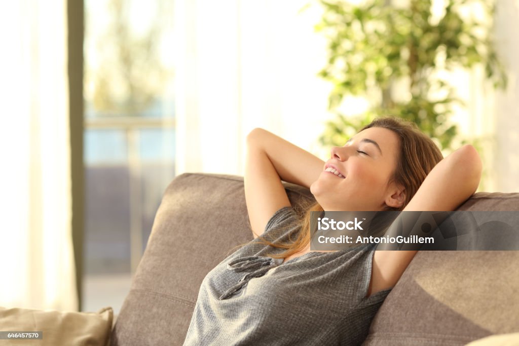 Relaxando em um sofá em casa de menina - Foto de stock de Vida doméstica royalty-free